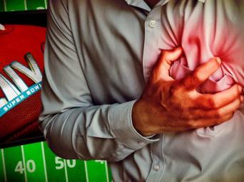 Man grabbing his heart next to LIV Super Bowl football