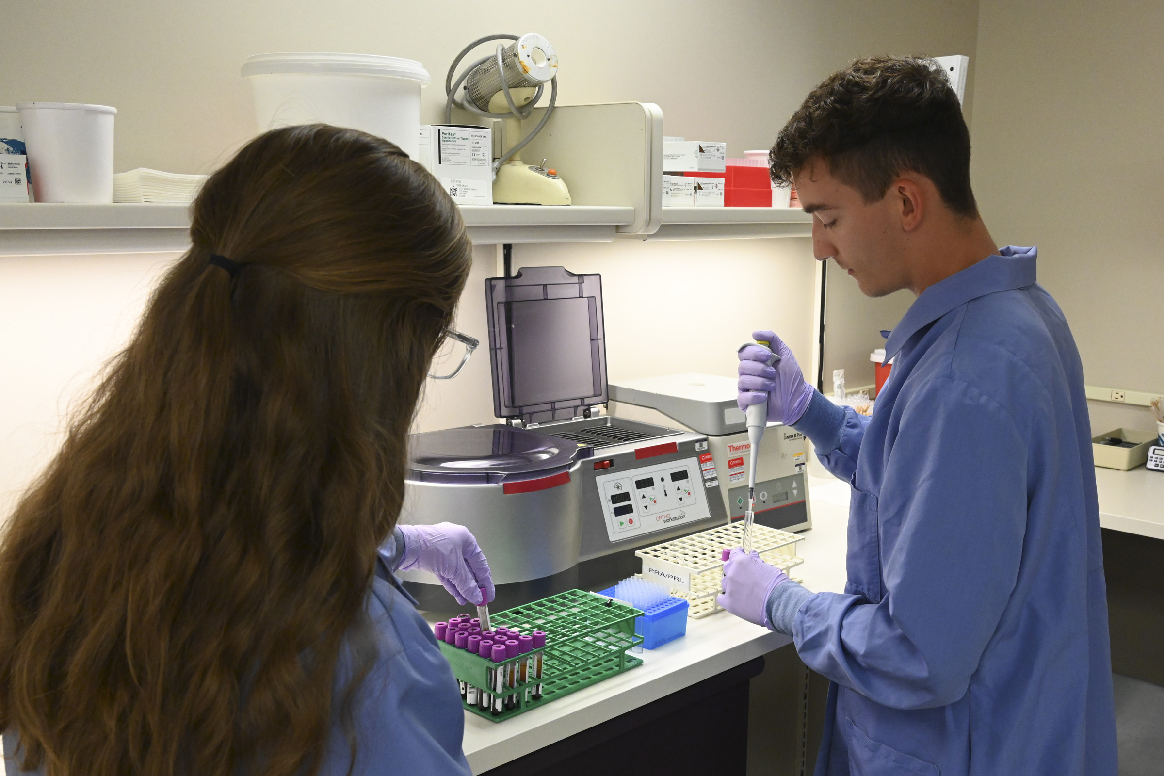 A Medical Laboratory Science student is looking at a machine