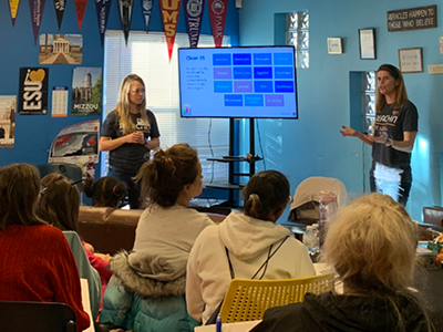 A presenter explaining the REACHN program to a group