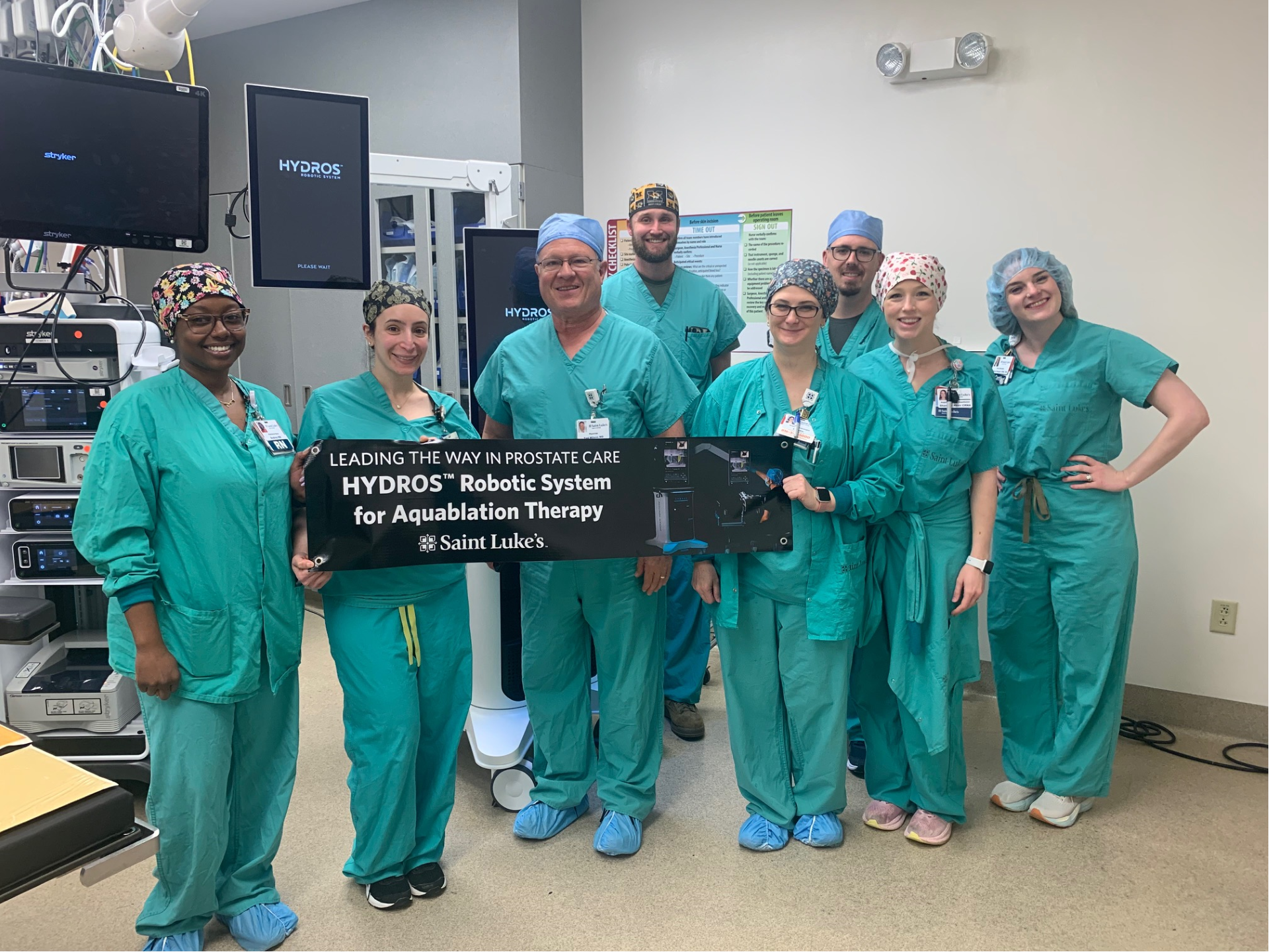 The Advanced Urologic Associates team in scrubs showing a sign about Aquablation
