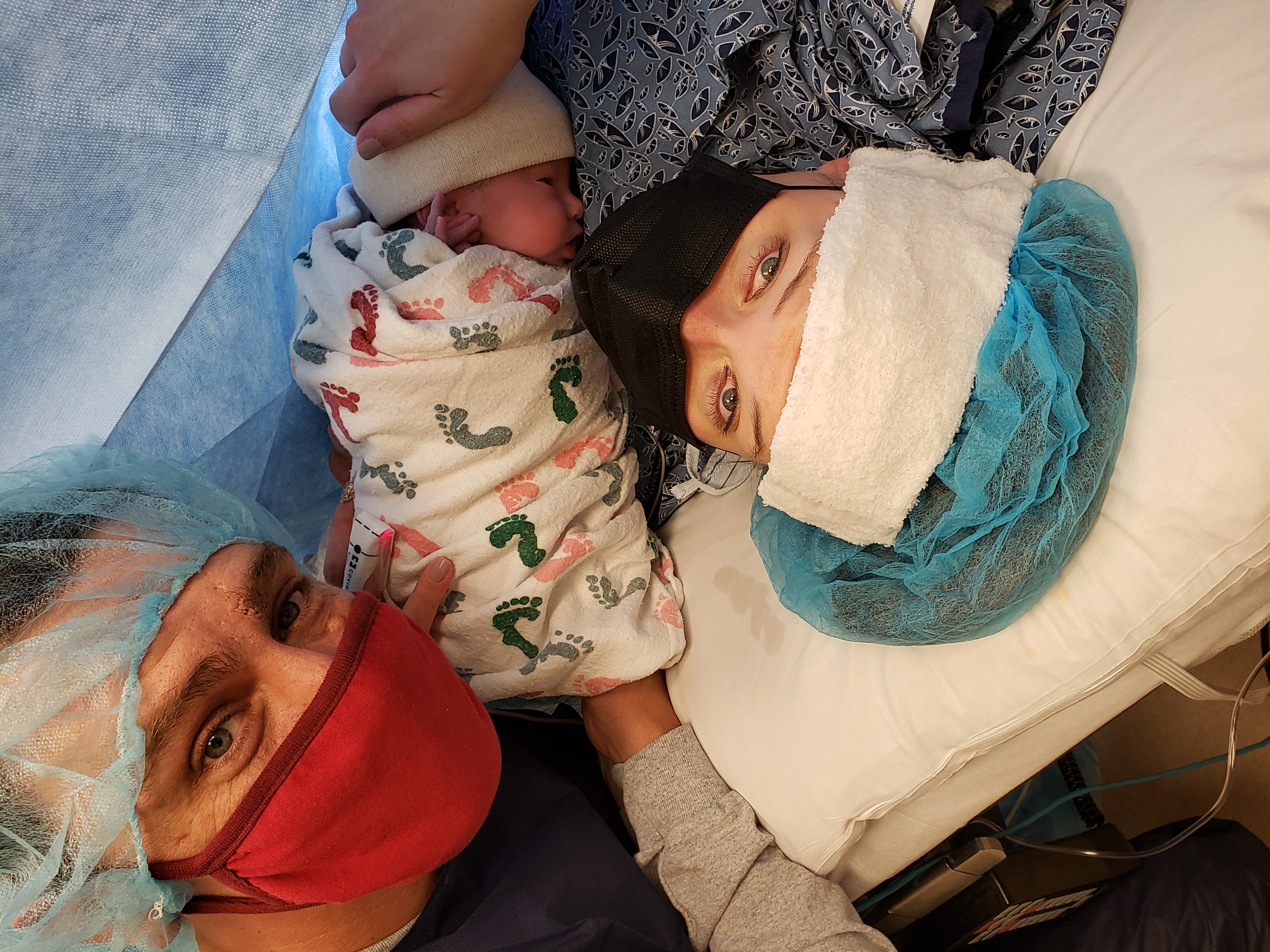 Jamie, holding her newborn during the C-section with her husband