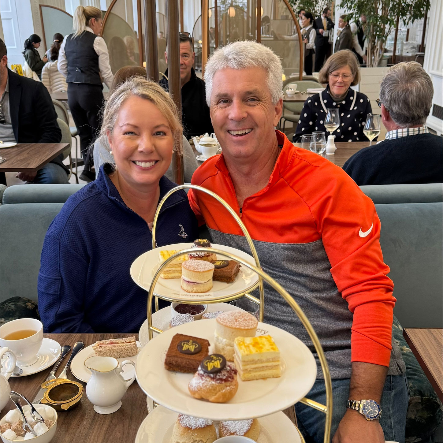 Annamarie, a Saint Luke's patient, is smiling with her husband in front of desserts in a restaurant.