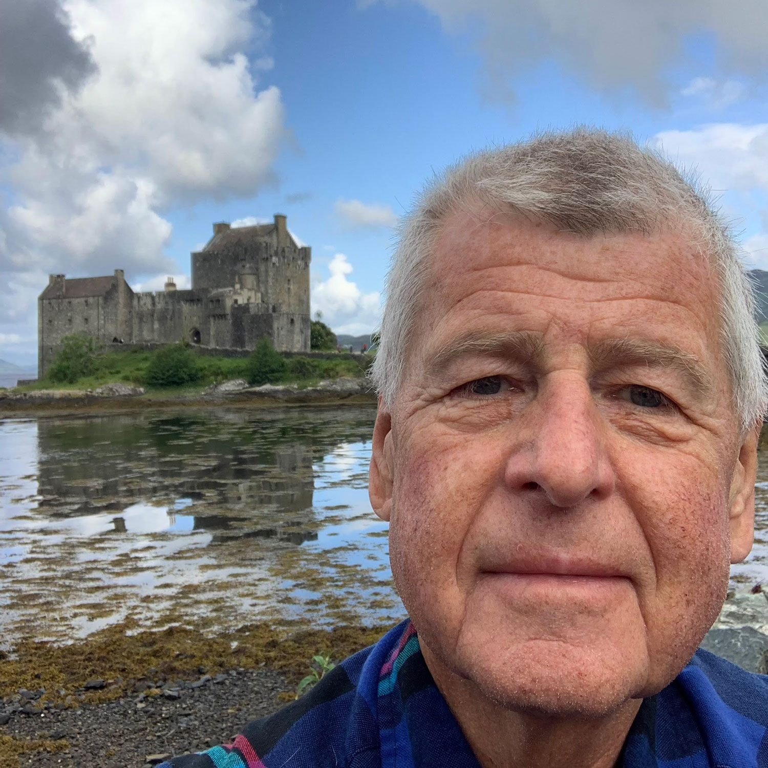 Ernest taking a selfie is front of a lake and a castle.
