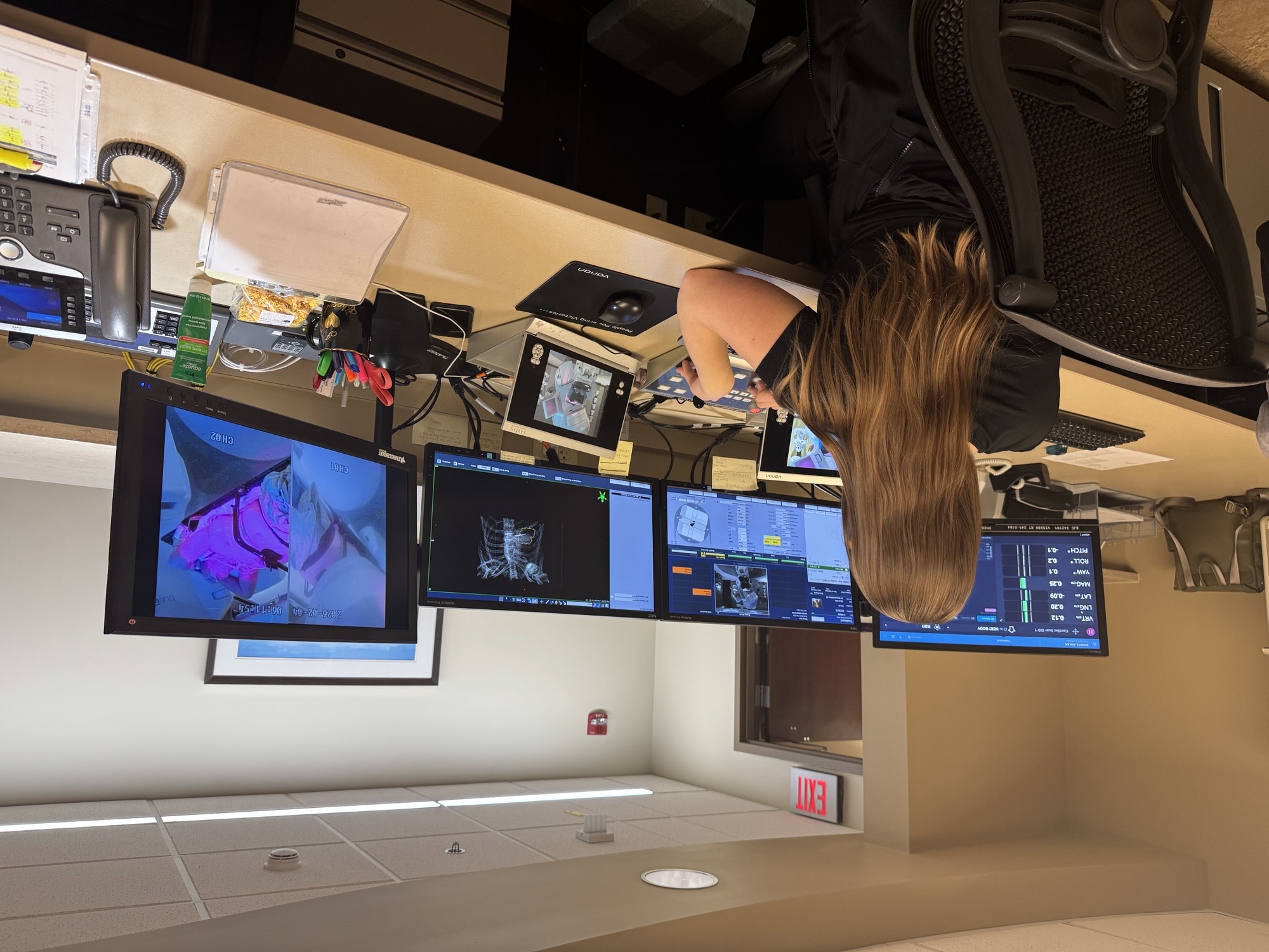 Medical professional overlooks four desktop computers with scans