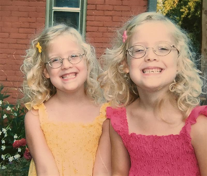 Annika and Peyton, twin toddlers formerly in the NICU, are outdoors smiling at the camera.