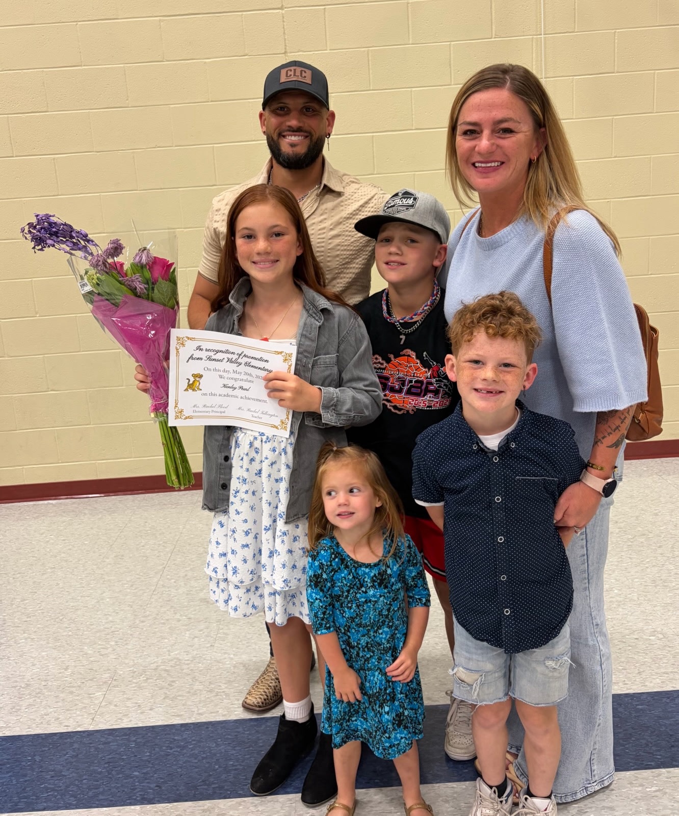 Karissa Pearl (right), 36, in a blue dress standing with husband and their four children 