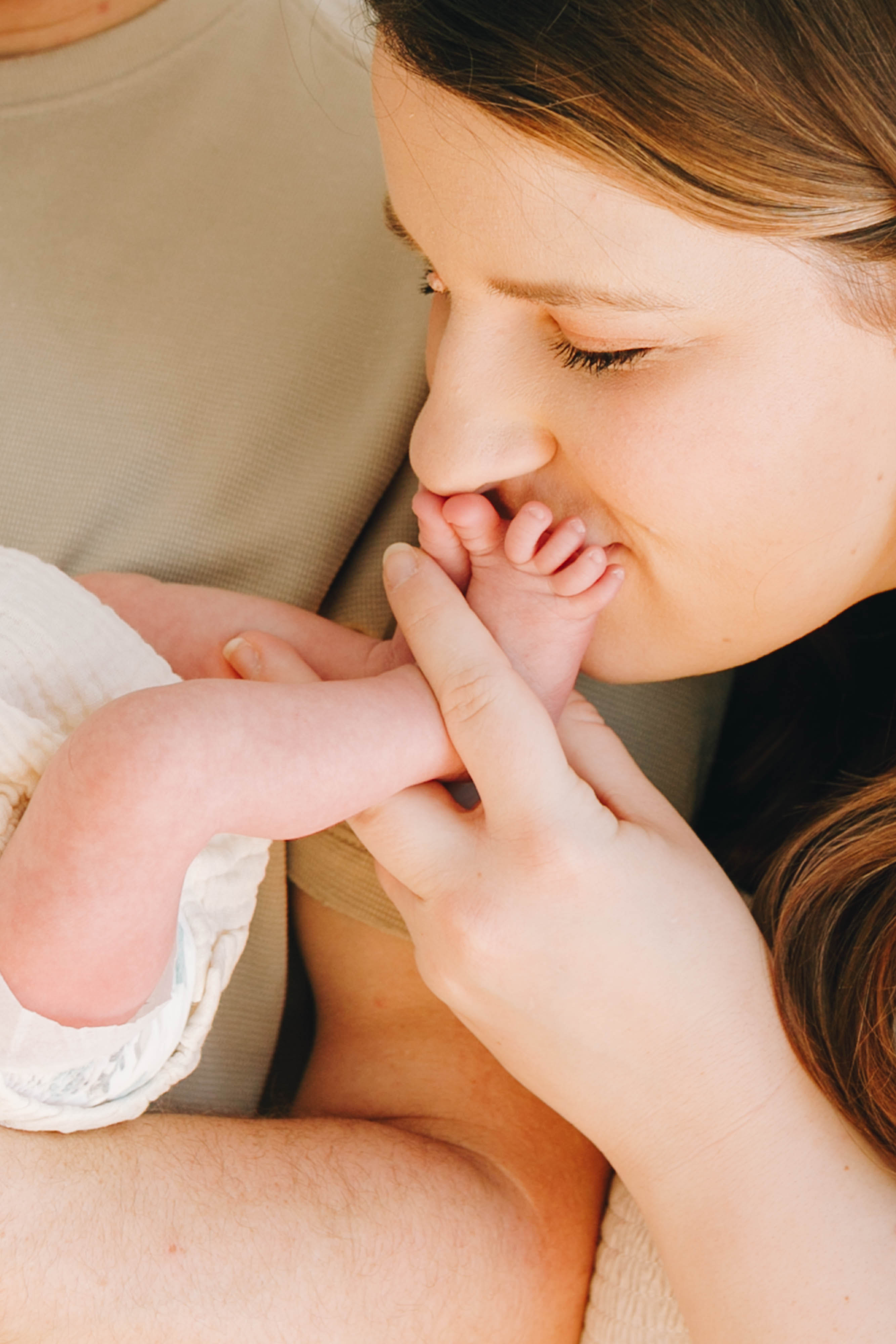 Katie Pinkgham face pictured, kissing newbory baby's toes 