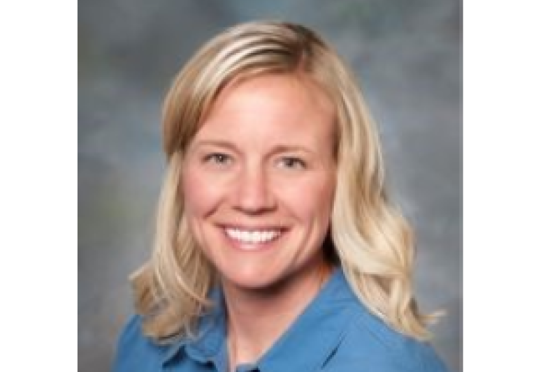 Holly Smith in blue shirt sitting for a portrait. 