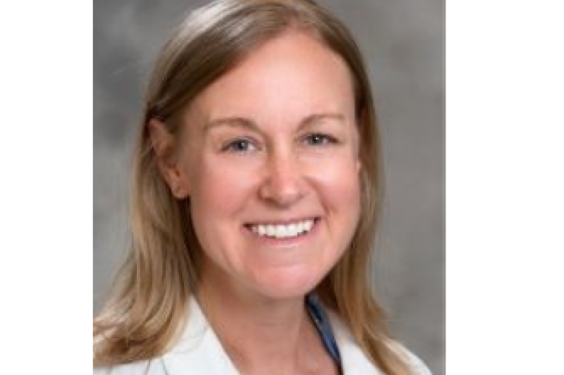 Shannon Lynn wearing white coat sitting for a portrait.