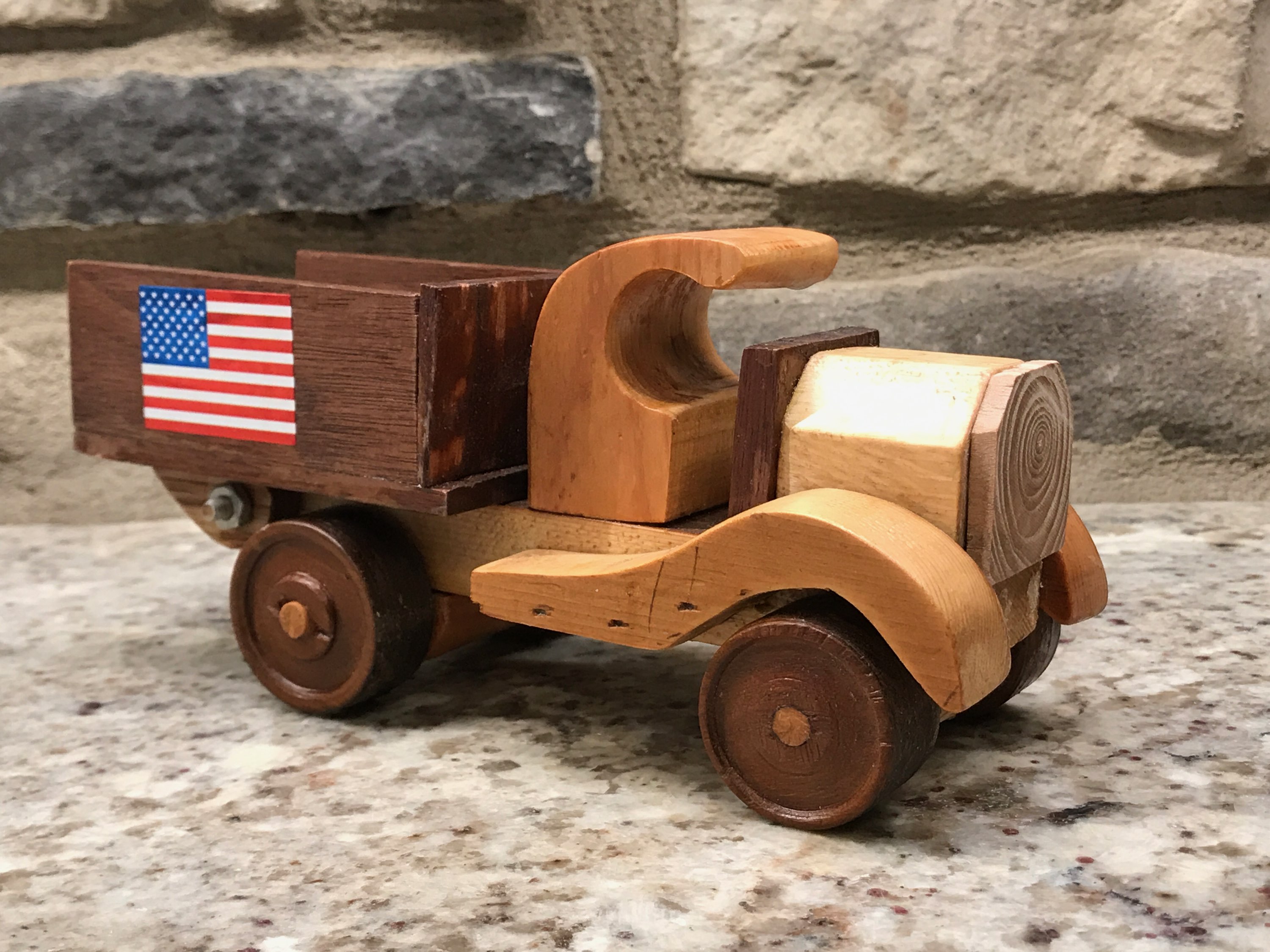 A handmade wooden toy truck with the American flag