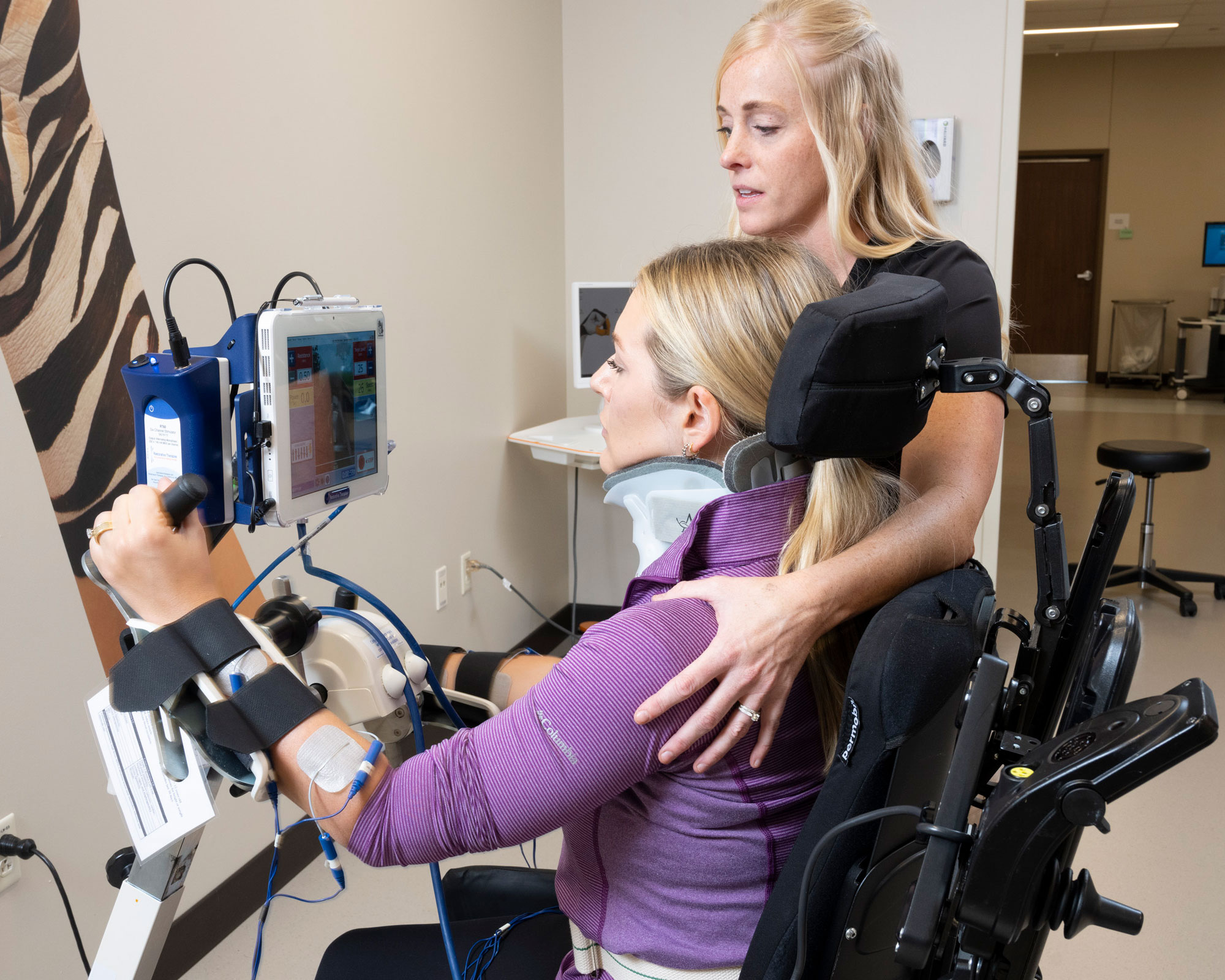 Therapist assists patient during upper extremity cycling therapy