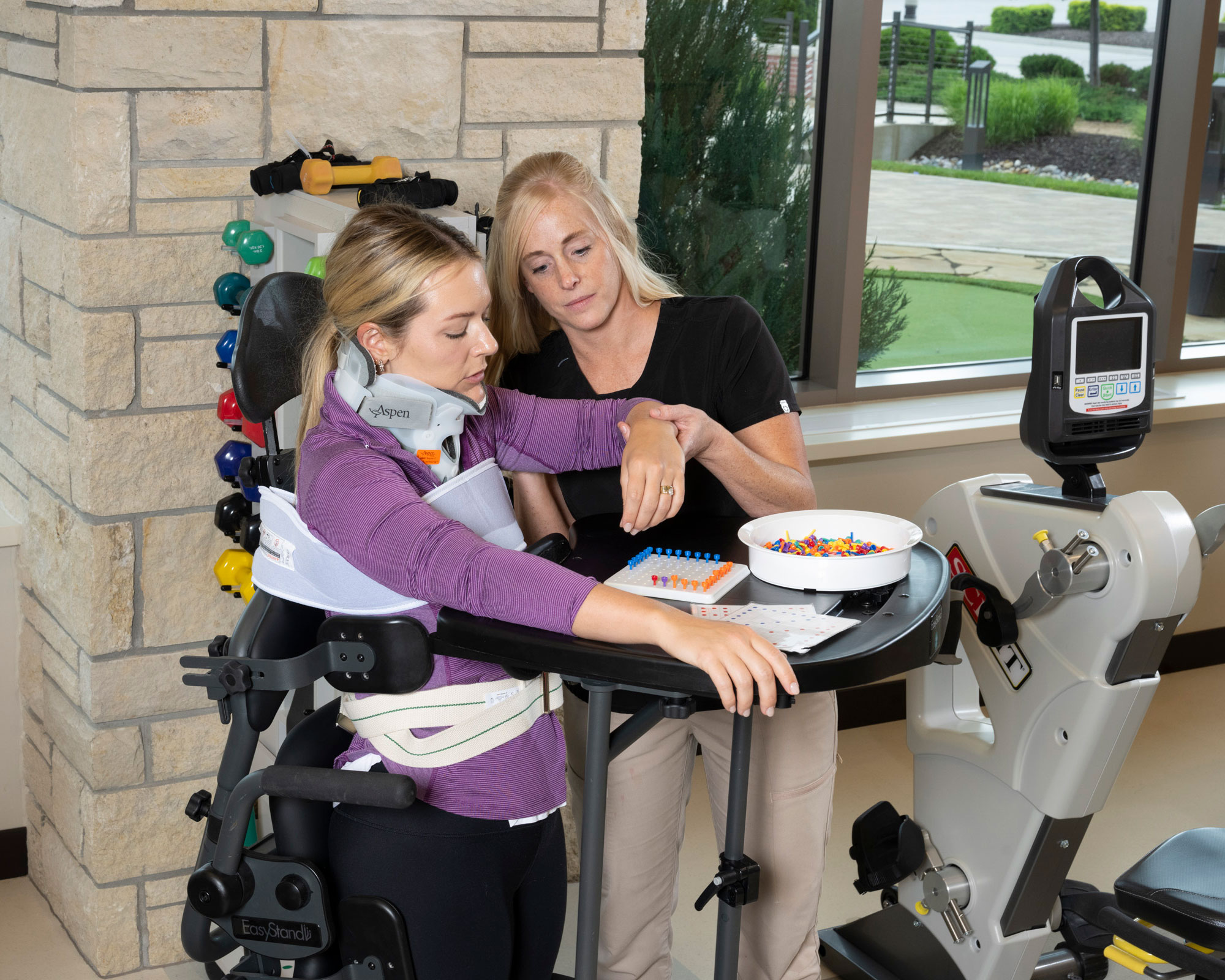 Patient participates in standing upper extremity hand therapy