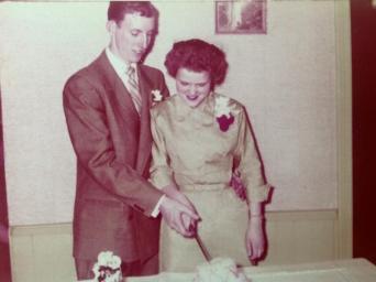 Jim and Rosie cutting cake at their wedding.